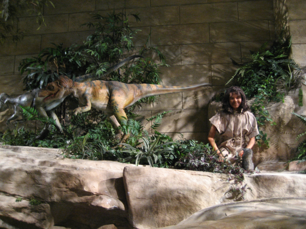 Photo taken at the Creation Museum showing dinosaurs and a child together.