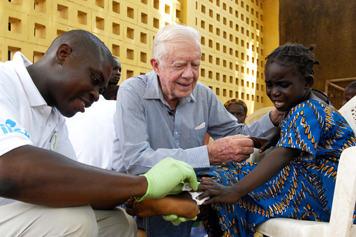 Photo of former President Jimmy Carter comforting a little girl with guinea worm disease.