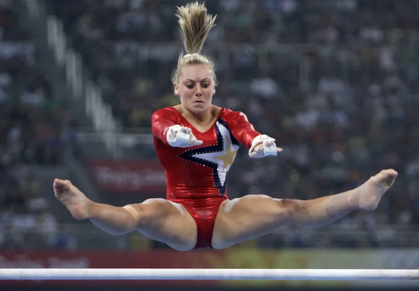 Photo of Samantha Peszek on the uneven parallel bars.