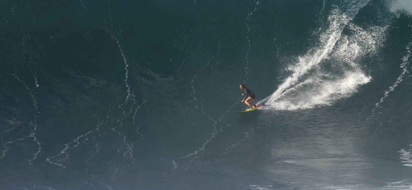 A photo by Erik Aeder of Paige Alms surfing a big wave, courtesy of www.paigealms.com