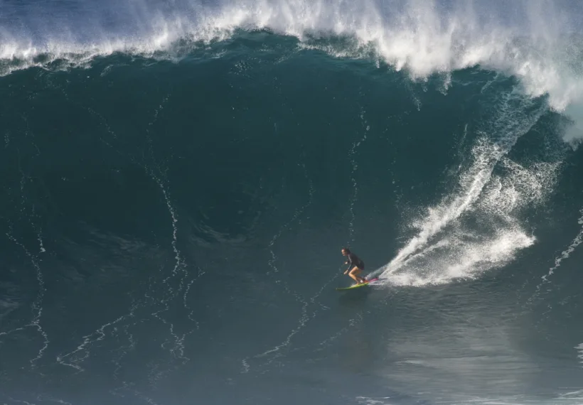 A photo by Erik Aeder of Paige Alms surfing a big wave, courtesy of www.paigealms.com