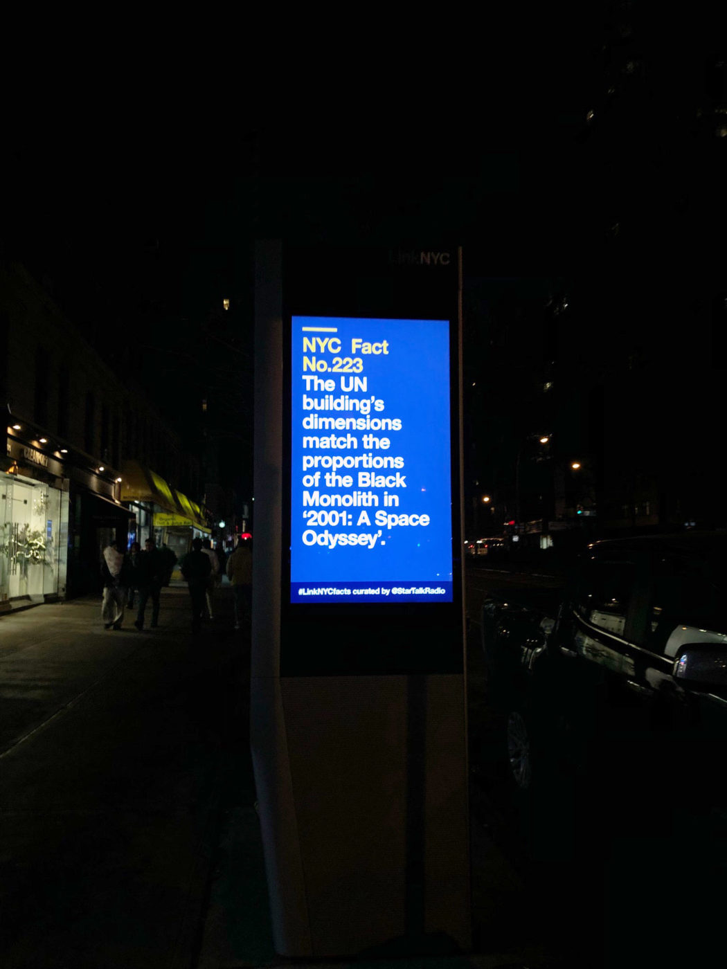 Another photo by Ben Ratner of a LinkNYC kiosk showing a science fact about the dimensions of the UN building matching the monolith in "2001: A Space Odyssey" curated by StarTalk and Neil deGrasse Tyson.