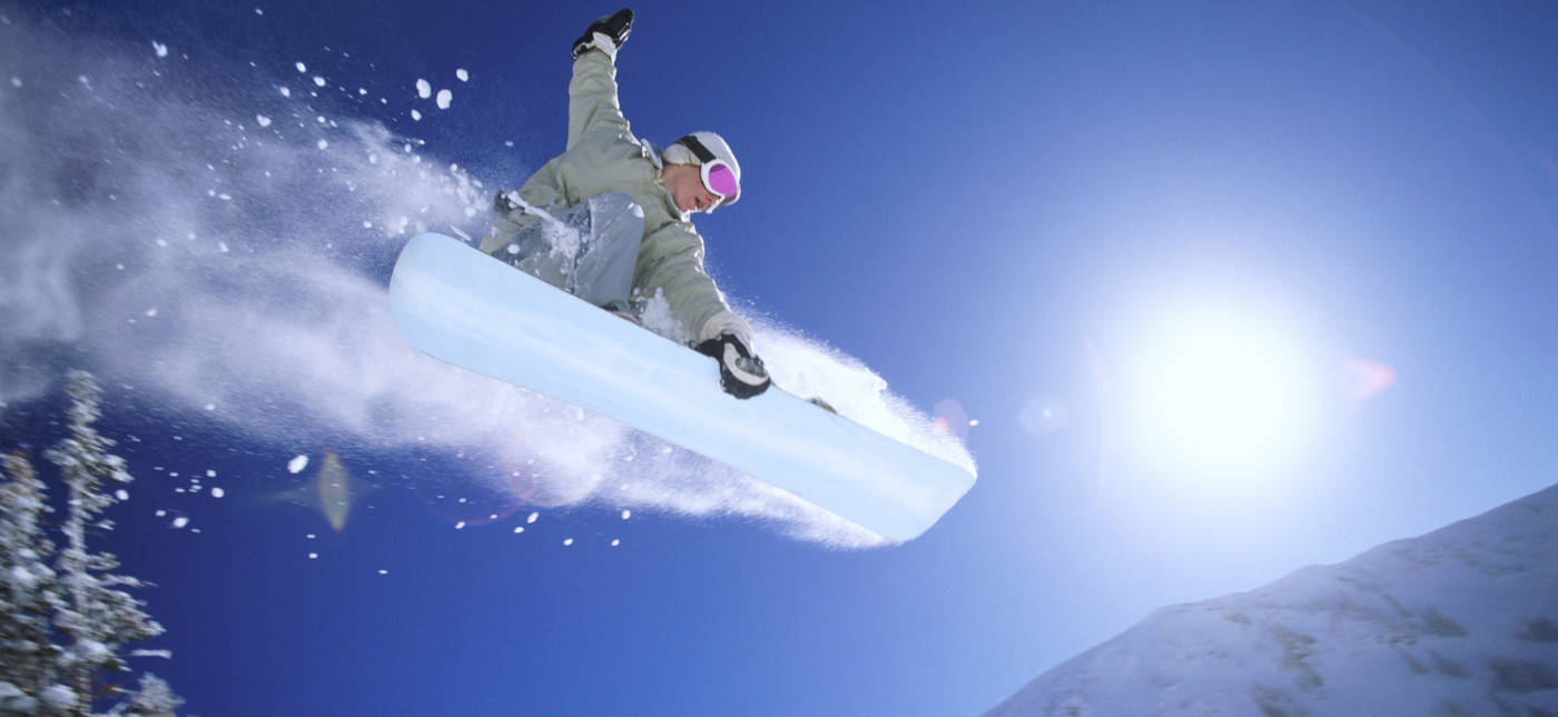 Photograph of a snowboader in a mid-air jump for a StarTalk Playing with Science episode about snowboarding. Credit: Digital Vision.