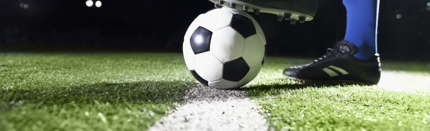 Photo for planet soccer showing soccer player’s foot and soccer ball. Credit: XiXinXing/iStock.