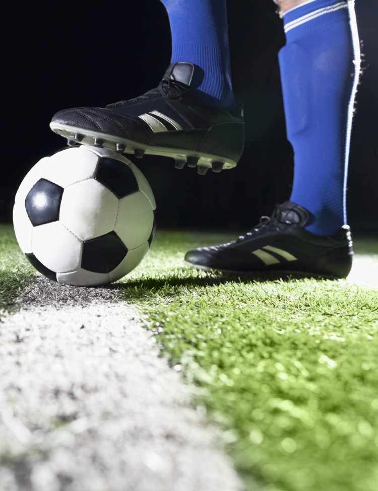 Photo for planet soccer showing soccer player’s foot and soccer ball. Credit: XiXinXing/iStock.