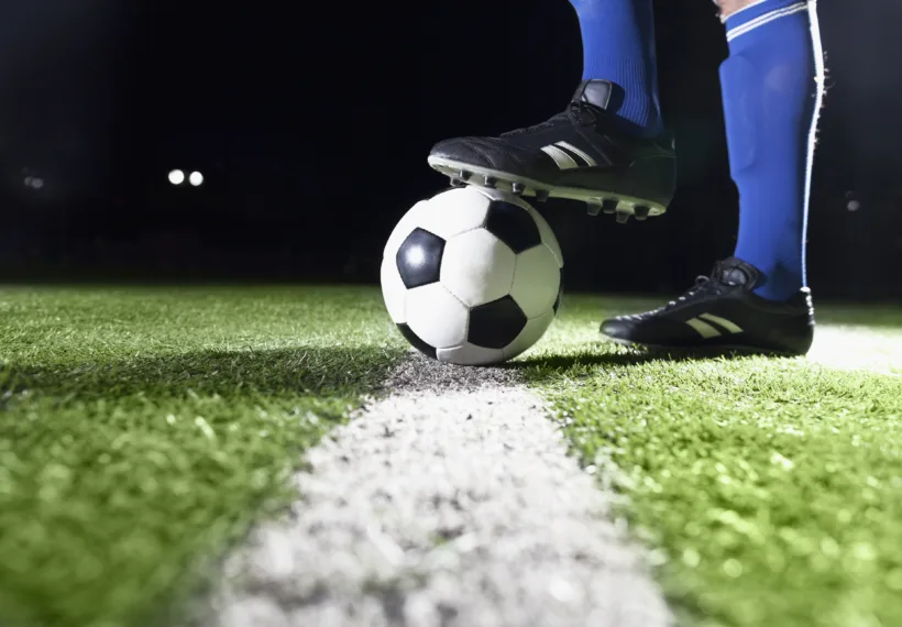 Photo for planet soccer showing soccer player’s foot and soccer ball. Credit: XiXinXing/iStock.