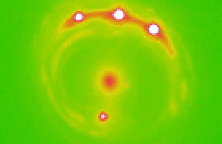 X-ray image from University of Oklahoma and NASA’s Chandra observatory showing dramatic gravitational lensing of the background quasar around a galaxy.