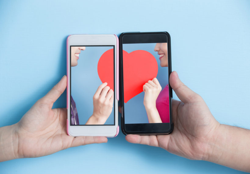 Photo of two cell phones each with half of the same heart on it, used for a StarTalk All-Stars episode about whether technology is changing love. Credit: RyanKing999/iStock.