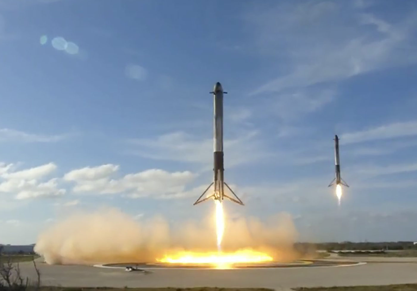 Screen capture of 2 Falcon Heavy Boosters landing at the same time, taken from SpaceX coverage of the event 2-6-18.