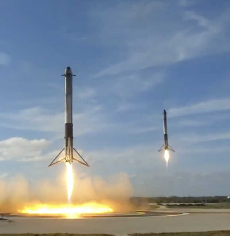 Screen capture of 2 Falcon Heavy Boosters landing at the same time, taken from SpaceX coverage of the event 2-6-18.