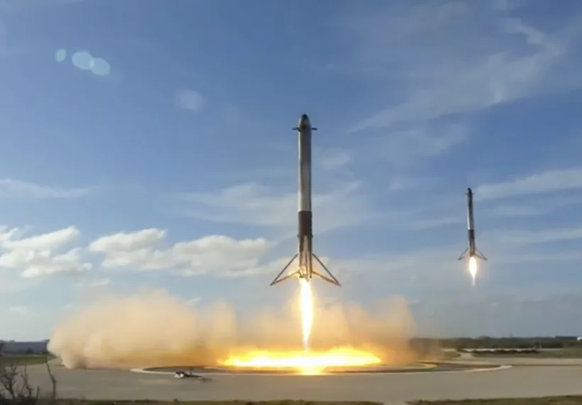 Screen capture of 2 Falcon Heavy Boosters landing at the same time, taken from SpaceX coverage of the event 2-6-18.