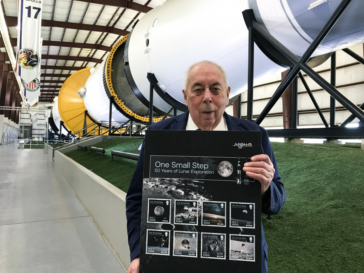 Ben Glazier's photo of George Abbey with the Apollo 11 50th Anniversary stamps in the Saturn V hangar at Johnson Space Center.