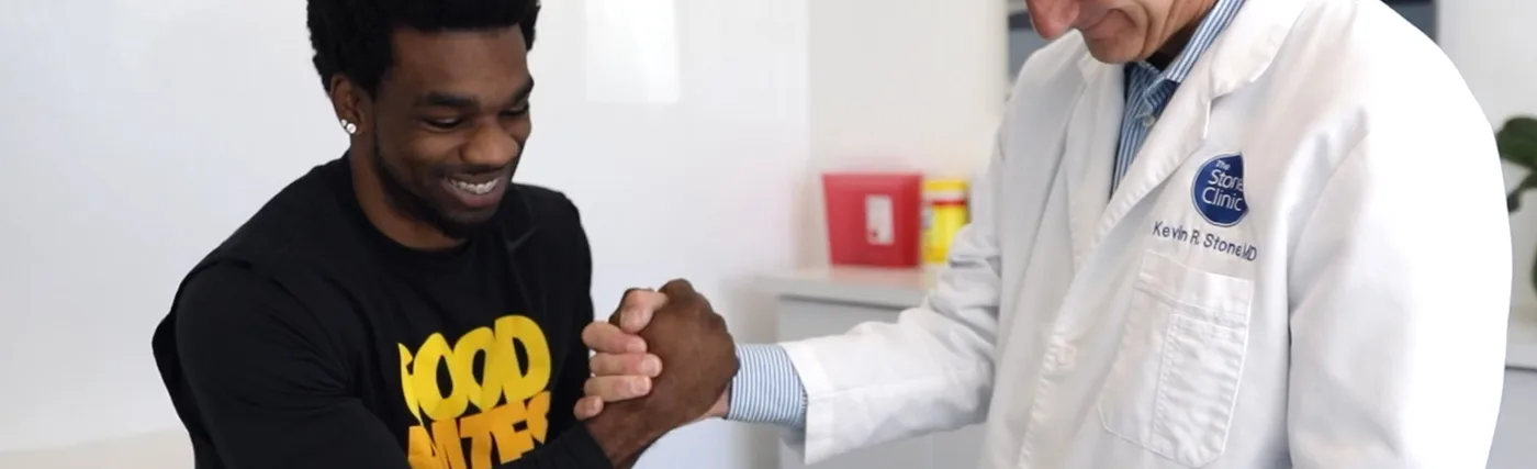Dr. Kevin Stone and Tracy Porter shaking hands. Credit The Stone Clinic.