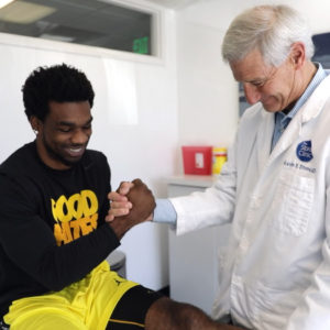 Dr. Kevin Stone and Tracy Porter shaking hands. Credit The Stone Clinic.