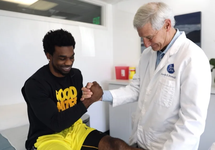 Dr. Kevin Stone and Tracy Porter shaking hands. Credit The Stone Clinic.