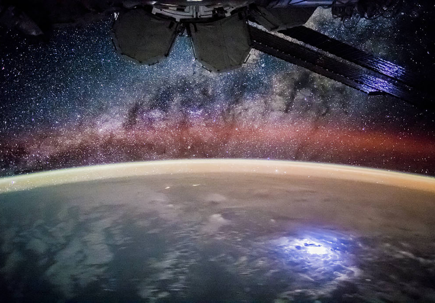 NASA’s photo from the International Space Station with a lightning storm on Earth below and the Milky Way above, taken by the Expedition 44 crew. 