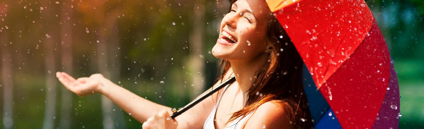 Storyblock’s photo of a laughing woman with an umbrella in the rain.