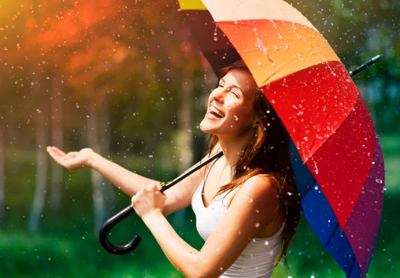 Storyblock’s photo of a laughing woman with an umbrella in the rain.