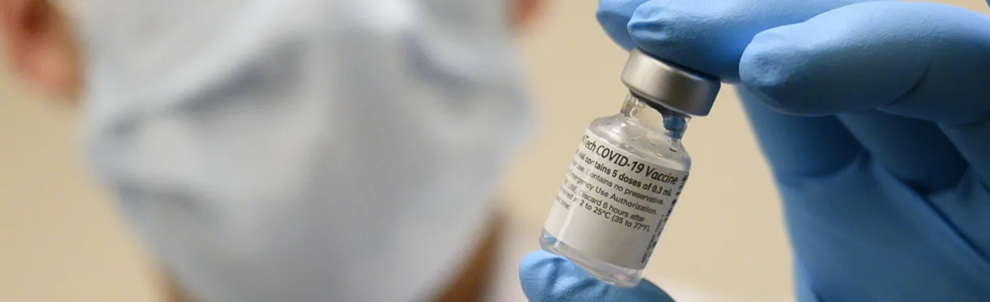 U.S Secretary of defense’s photo of Army Spc. Angel Laureano holds a vial of the COVID-19 vaccine, Walter Reed National Military Medical Center, Bethesda, Md., Dec. 14, 2020. (DoD photo by Lisa Ferdinando)
