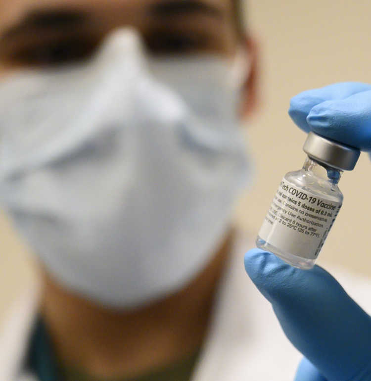 U.S Secretary of defense’s photo of Army Spc. Angel Laureano holds a vial of the COVID-19 vaccine, Walter Reed National Military Medical Center, Bethesda, Md., Dec. 14, 2020. (DoD photo by Lisa Ferdinando)