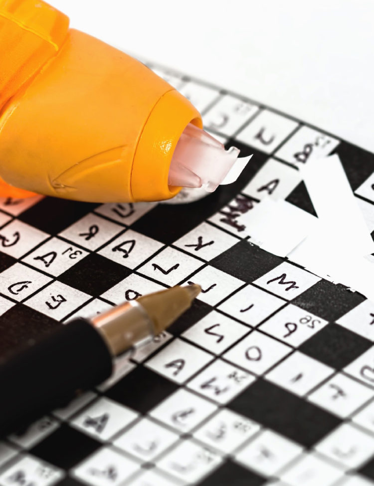 Photo of glasses on newspaper with crossword puzzle