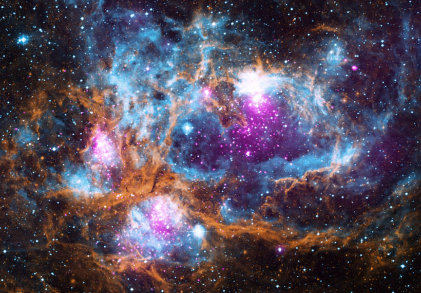 Composite image contains X-ray data from NASA’s Chandra X-ray Observatory and the ROSAT telescope (purple), infrared data from NASA’s Spitzer Space Telescope (orange), and optical data from the SuperCosmos Sky Survey (blue) made by the United Kingdom Infrared Telescope.