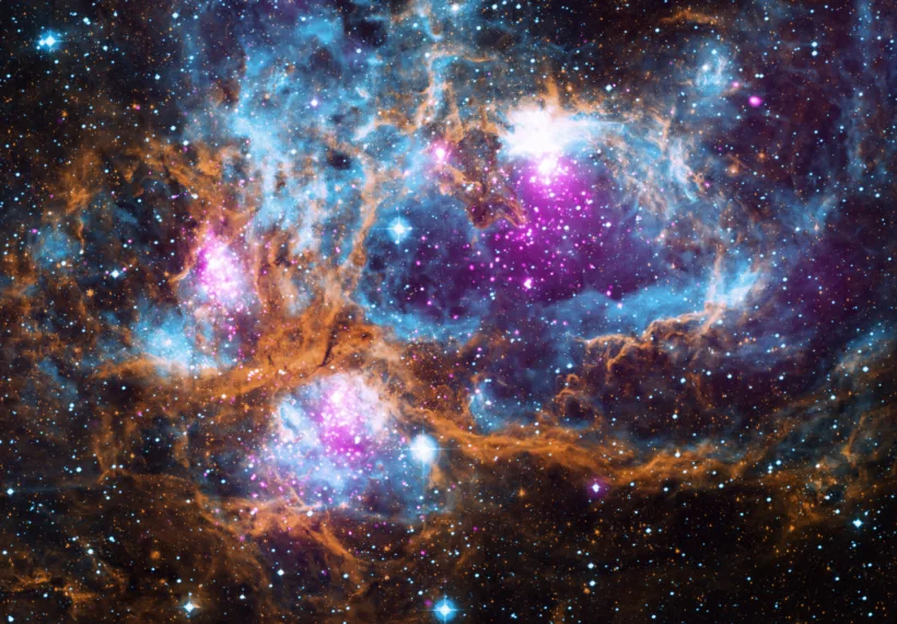 Composite image contains X-ray data from NASA’s Chandra X-ray Observatory and the ROSAT telescope (purple), infrared data from NASA’s Spitzer Space Telescope (orange), and optical data from the SuperCosmos Sky Survey (blue) made by the United Kingdom Infrared Telescope.
