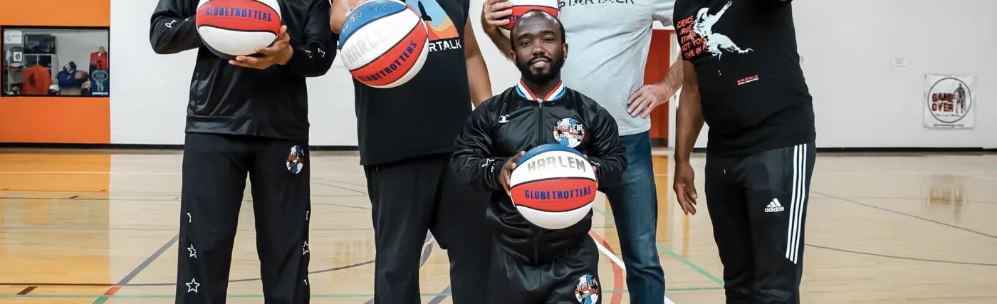 StarTalk Sports Edition team with two members of the Harlem Globetrotters posing with basketballs.