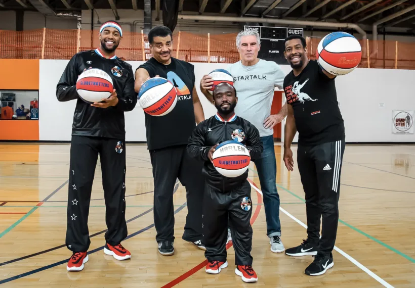 StarTalk Sports Edition team with two members of the Harlem Globetrotters posing with basketballs.