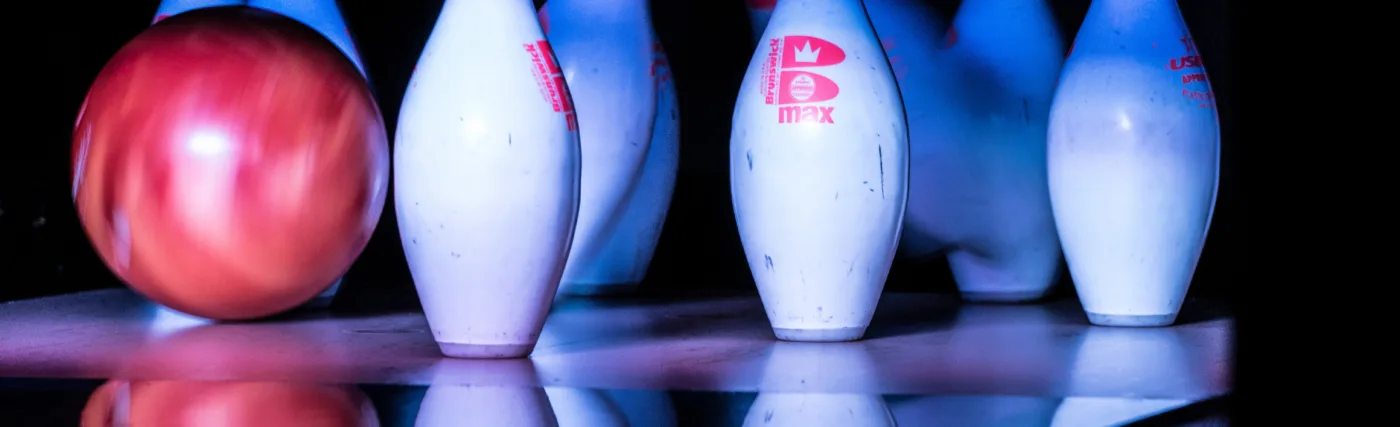 Bowling pins being hit by a bowling ball.
