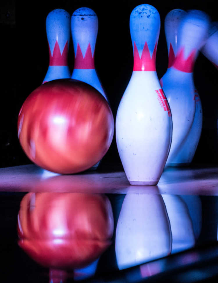 Bowling pins being hit by a bowling ball.