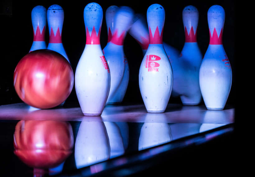 Bowling pins being hit by a bowling ball.