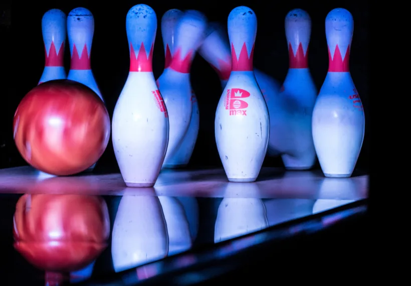 Bowling pins being hit by a bowling ball.