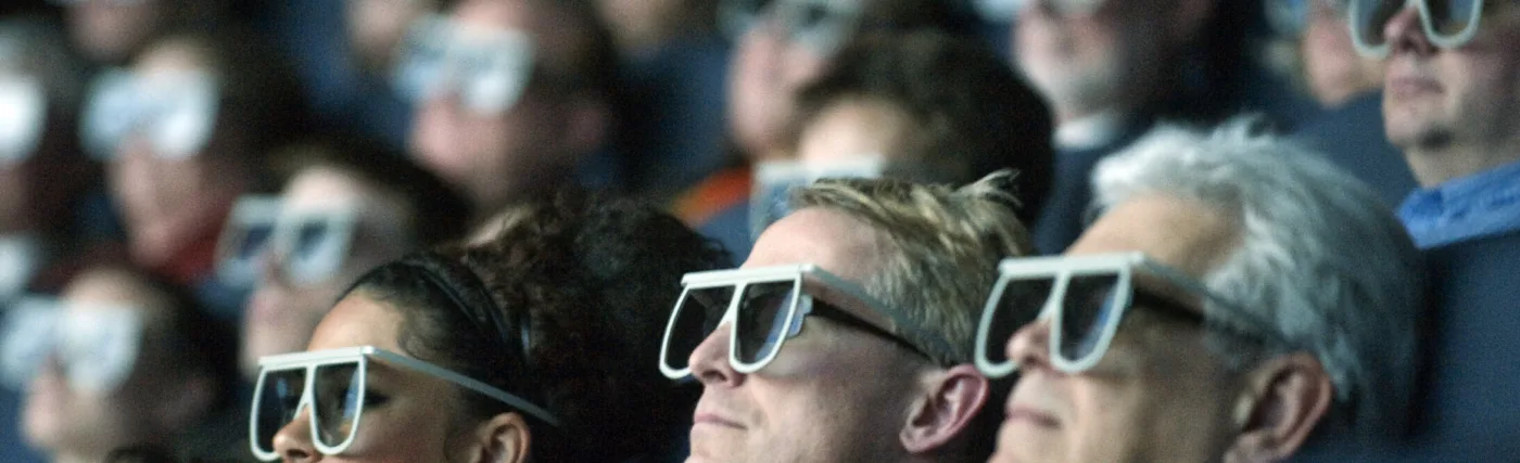 Moviegoers wear 3D glasses as they watch the world premiere of "Hubble 3D," screened at the Smithsonian's Air and Space Museum