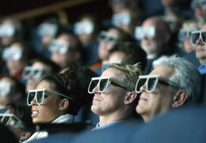 Moviegoers wear 3D glasses as they watch the world premiere of "Hubble 3D," screened at the Smithsonian's Air and Space Museum