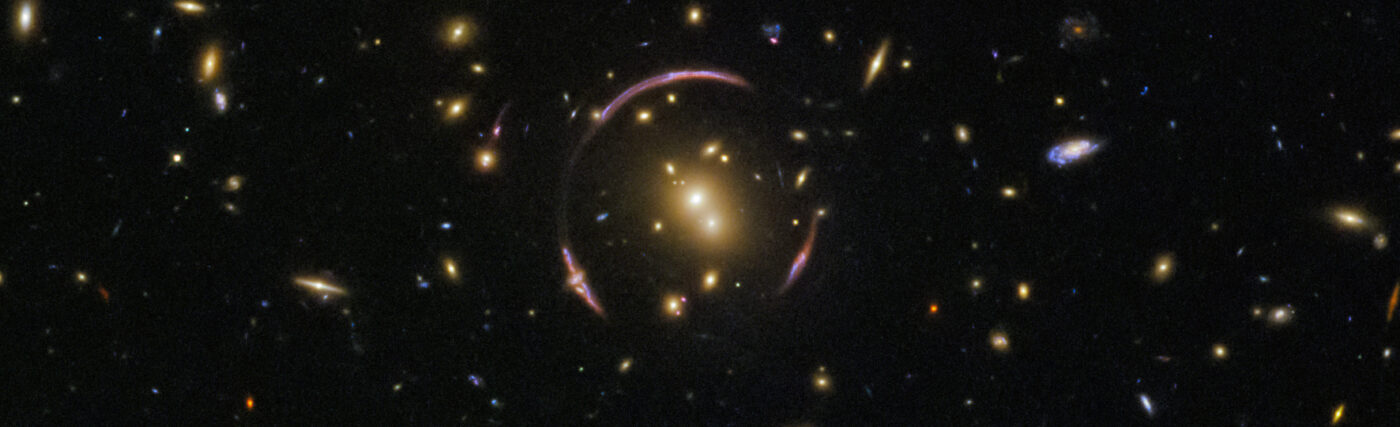 These graceful arcs are examples of a cosmic phenomenon known as an Einstein ring. The ring is created as the light from a distant objects, like galaxies, pass by an extremely large mass, like this galaxy cluster. In this image, the light from a background galaxy is diverted and distorted around the massive intervening cluster and forced to travel along many different light paths towards Earth, making it seem as though the galaxy is in several places at once.