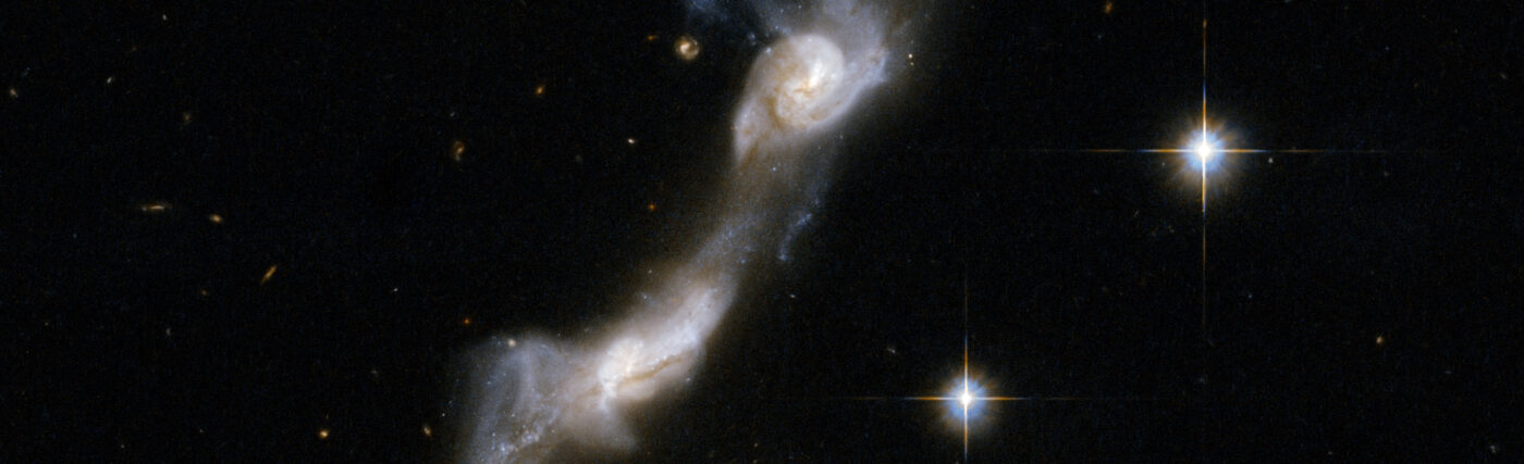 UGC 8335 is a strongly interacting pair of spiral galaxies resembling two ice skaters. The interaction has united the galaxies via a bridge of material and has yanked two strongly curved tails of gas and stars from the outer parts of their bodies . Both galaxies show dust lanes in their centers. UGC 8335 is located in the constellation of Ursa Major, the Great Bear, about 400 million light-years from Earth. It is the 238th galaxy in Arp's Atlas of Peculiar Galaxies.