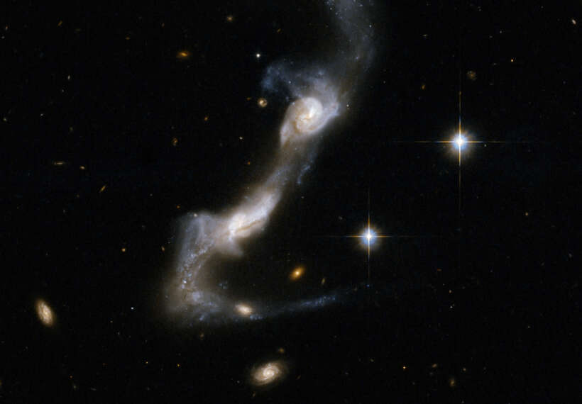 UGC 8335 is a strongly interacting pair of spiral galaxies resembling two ice skaters. The interaction has united the galaxies via a bridge of material and has yanked two strongly curved tails of gas and stars from the outer parts of their bodies . Both galaxies show dust lanes in their centers. UGC 8335 is located in the constellation of Ursa Major, the Great Bear, about 400 million light-years from Earth. It is the 238th galaxy in Arp's Atlas of Peculiar Galaxies.
