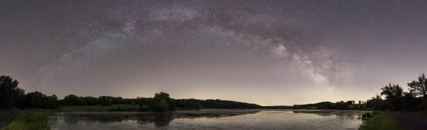 Panorama of the Milky Way galactic plane stretching over Bontecou Lake in Dutchess County, New York.