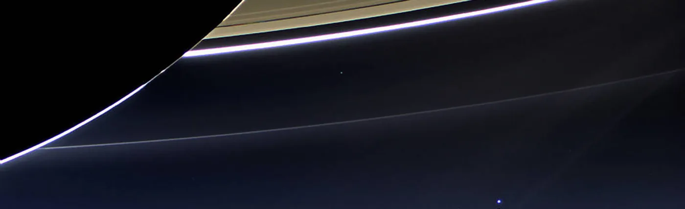 NASA's Cassini spacecraft photographs Earth from Saturn, 900 million miles away. Earth is pointed out by an arrow.
