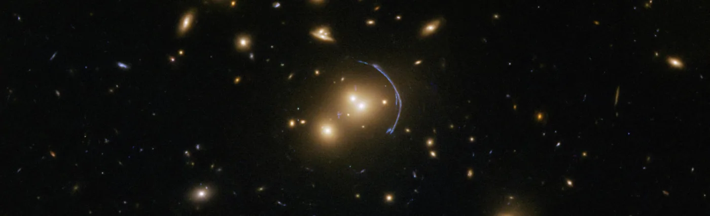 This Hubble Space Telescope image demonstrates the immense effects of gravity; more specifically, it shows the effects of gravitational lensing caused by a cluster of galaxies called SDSS J1152+3313. Gravitational lenses possess immense masses that warp their surroundings and bend the light from faraway objects into rings, arcs, streaks, blurs, and other odd shapes.