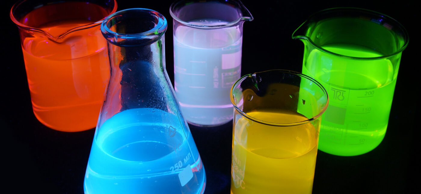 On this picture you can see fluorescence of different substances under UV light. Green is a fluorescein, red is Rhodamine B, yellow is Rhodamine 6G, blue is quinine, purple is a mixture of quinine and rhodamine 6g. Solutions are about 0.001% concentration in water.
