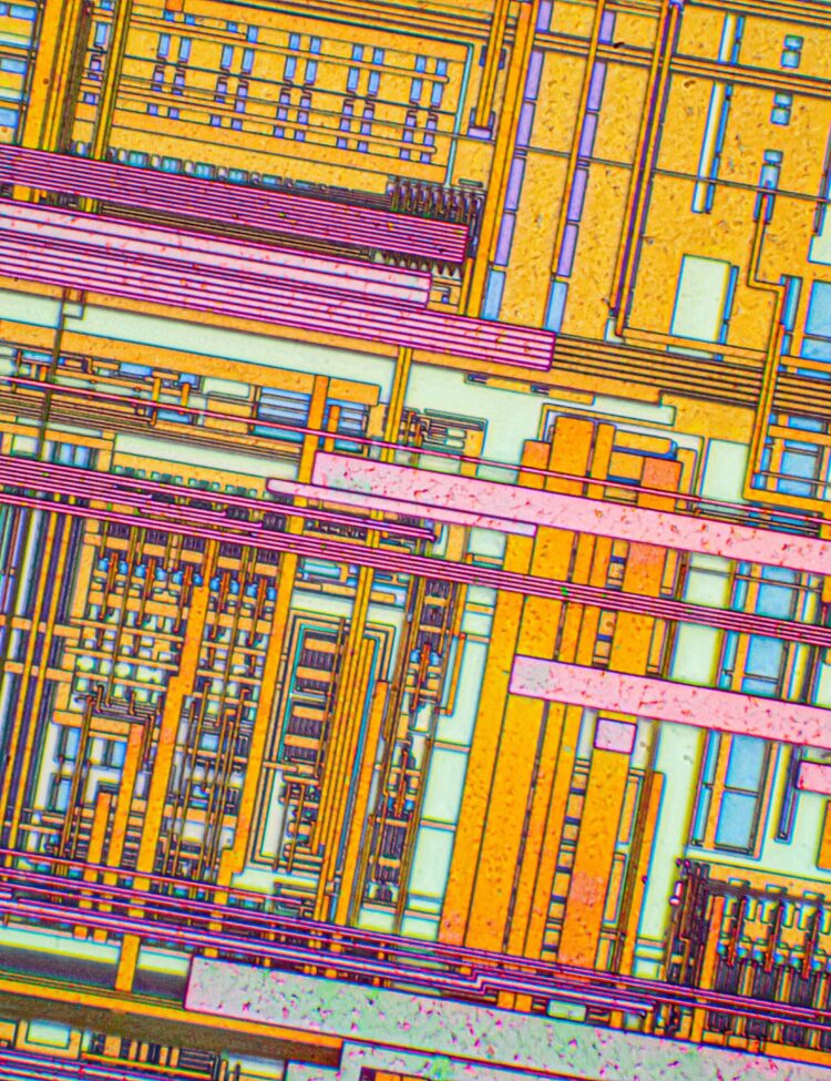Silicon chip from a computer laser mouse under a microscope. Differential-interference contrast of reflected light. 50x magnification