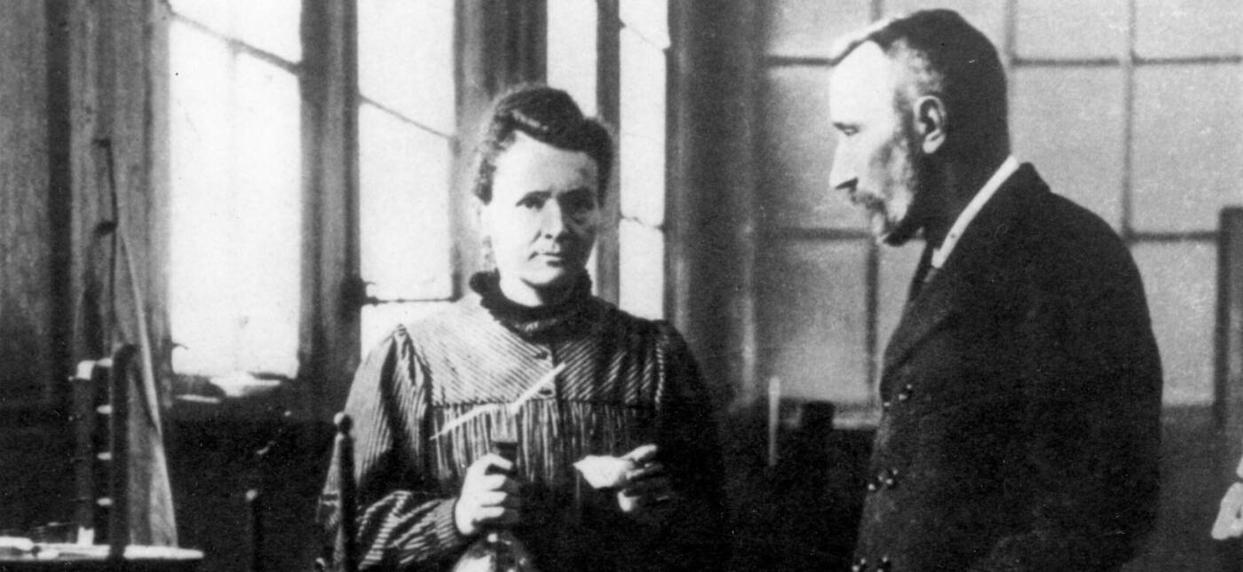 Husband and wife team Marie and Pierre Curie converse in their laboratory.