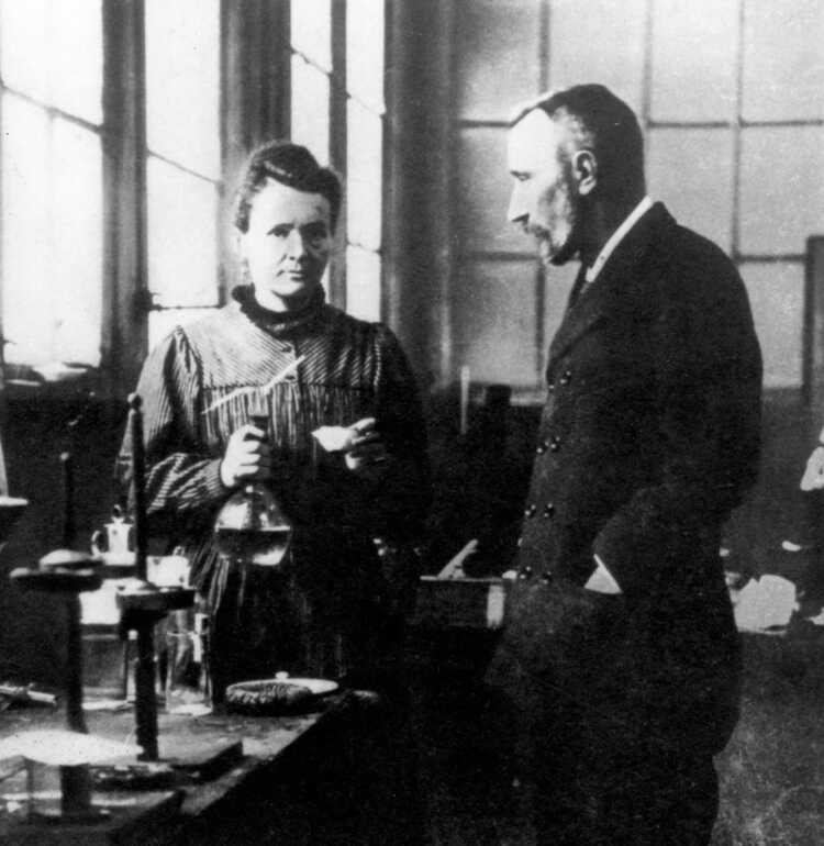 Husband and wife team Marie and Pierre Curie converse in their laboratory.