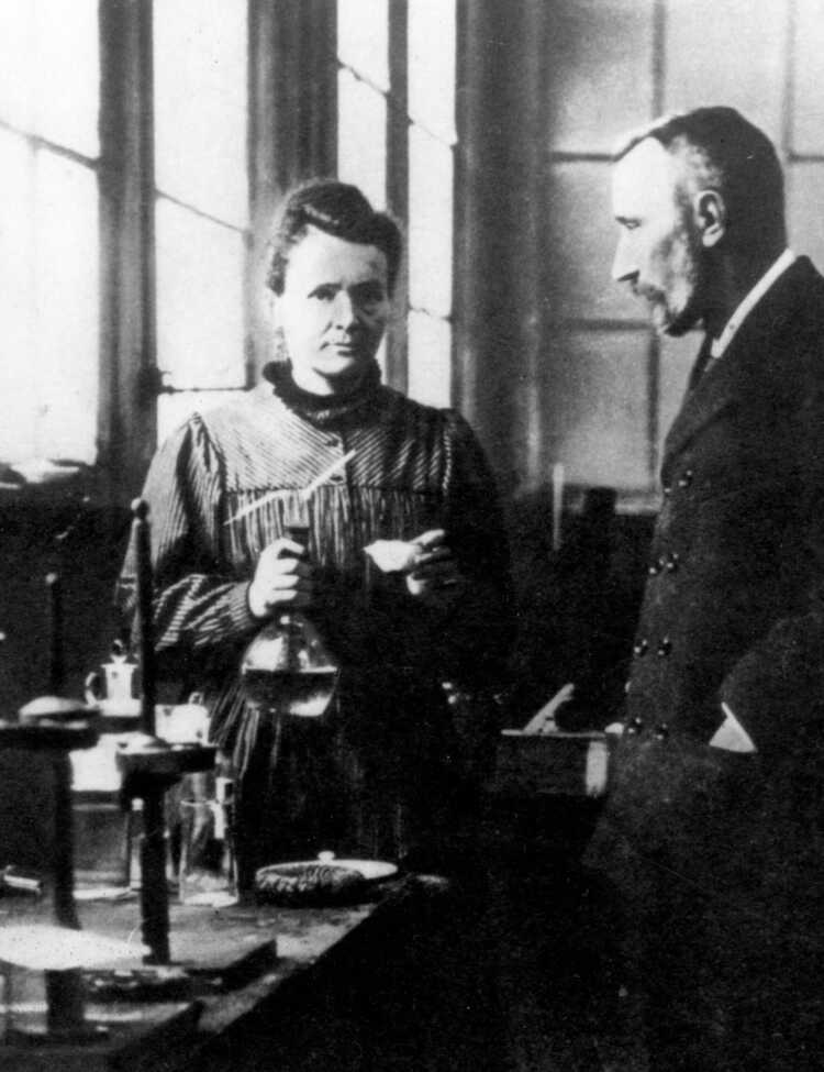 Husband and wife team Marie and Pierre Curie converse in their laboratory.