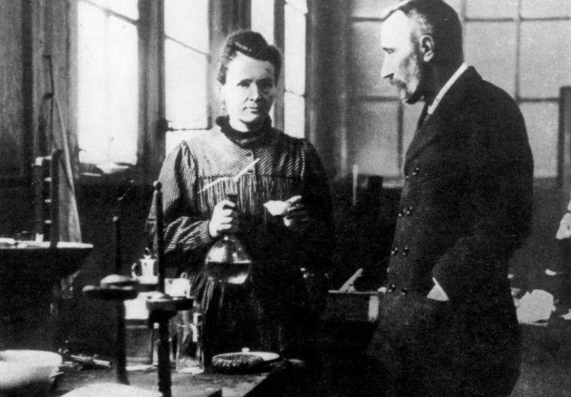 Husband and wife team Marie and Pierre Curie converse in their laboratory.