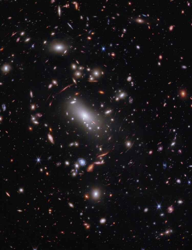 Thousands of glimmering galaxies are bound together by their own gravity, making up a massive cluster formally classified as MACS J1423.