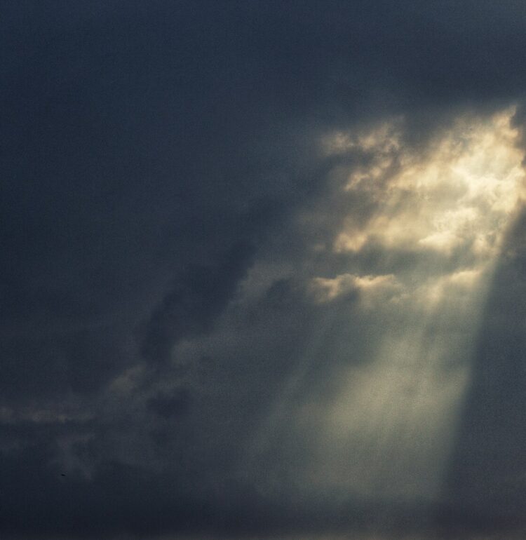 The warm light of the Sun punches through the darkness of the Storm.