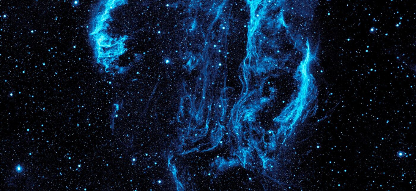 Wispy tendrils of hot dust and gas glow brightly in this ultraviolet image of the Cygnus Loop Nebula, taken by NASA’s Galaxy Evolution Explorer.